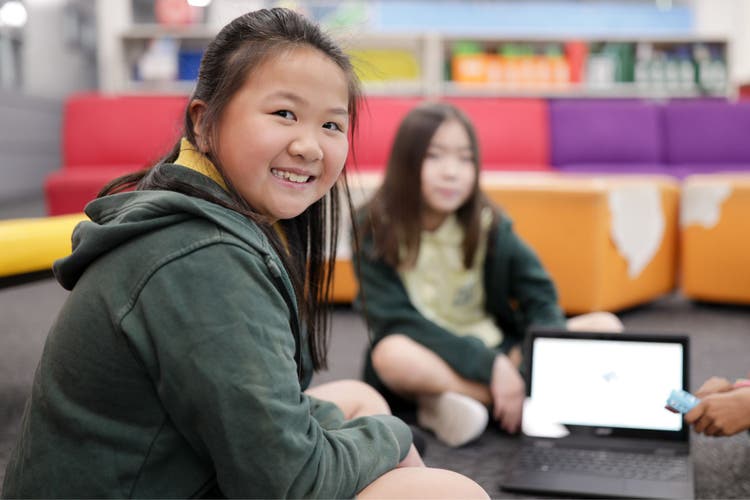 Photograph of a student looking at the camera while completing a computer task.