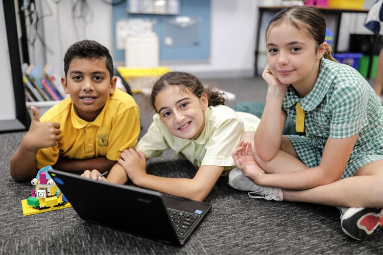 Photograph of three students completing a group activity on the laptop.