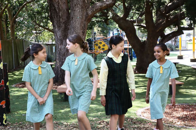 Photograph of four students walking and looking at each other.