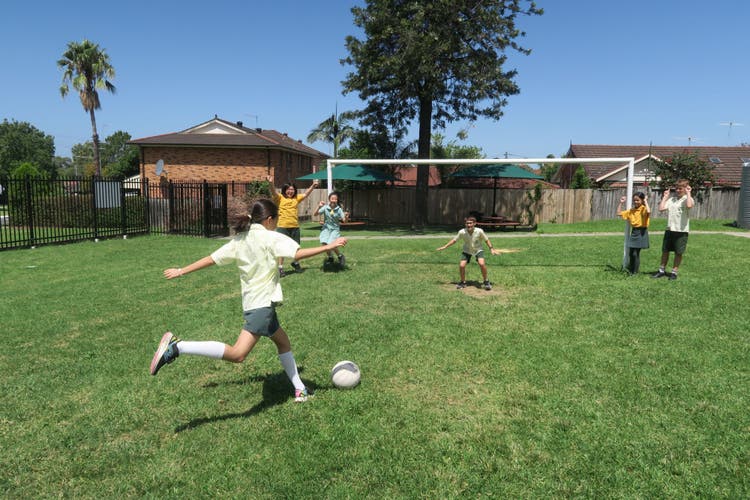 Photograph of students playing soccer on the school field.