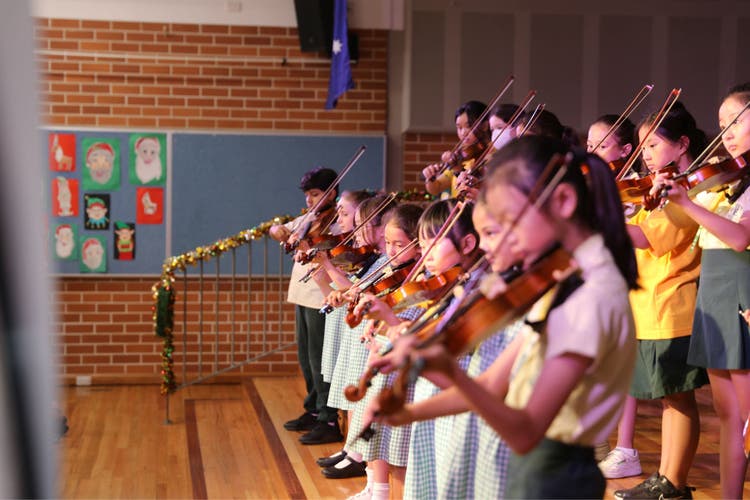 Photograph of students playing the violin.