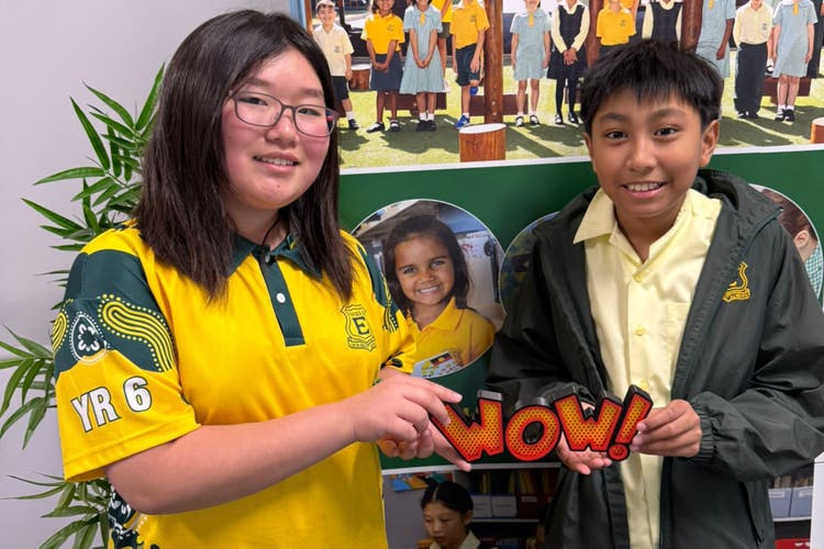 Photograph of two students holding a wow sign.