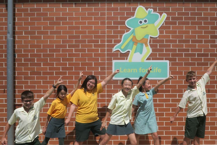 Photograph of student leaders posing in front of school's PBL mascot Captain Star.