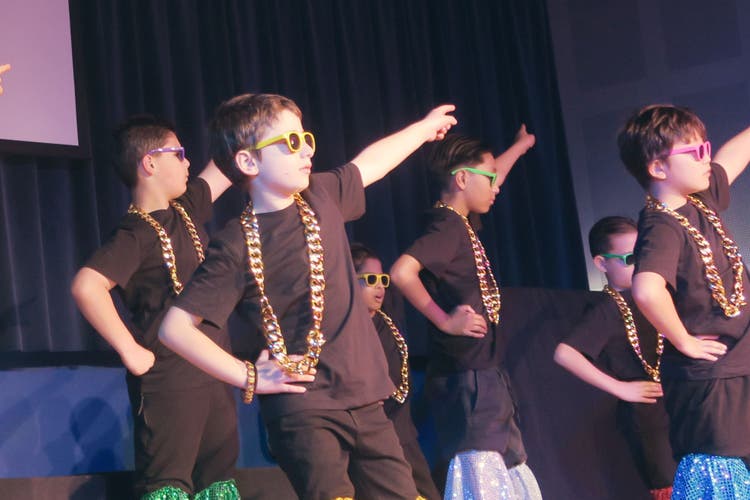 Photograph of boys dancing during a whole school performing arts showcase.